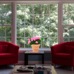 Alltag bewältigen 2 rote Sessel vor einem großen Fenster mit Sicht in die Landschaft